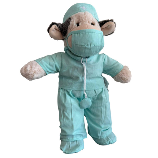 Knuffel koe verkleed in mintgroene dokter outfit met shirt, broek, pantoffels en stethoscoop