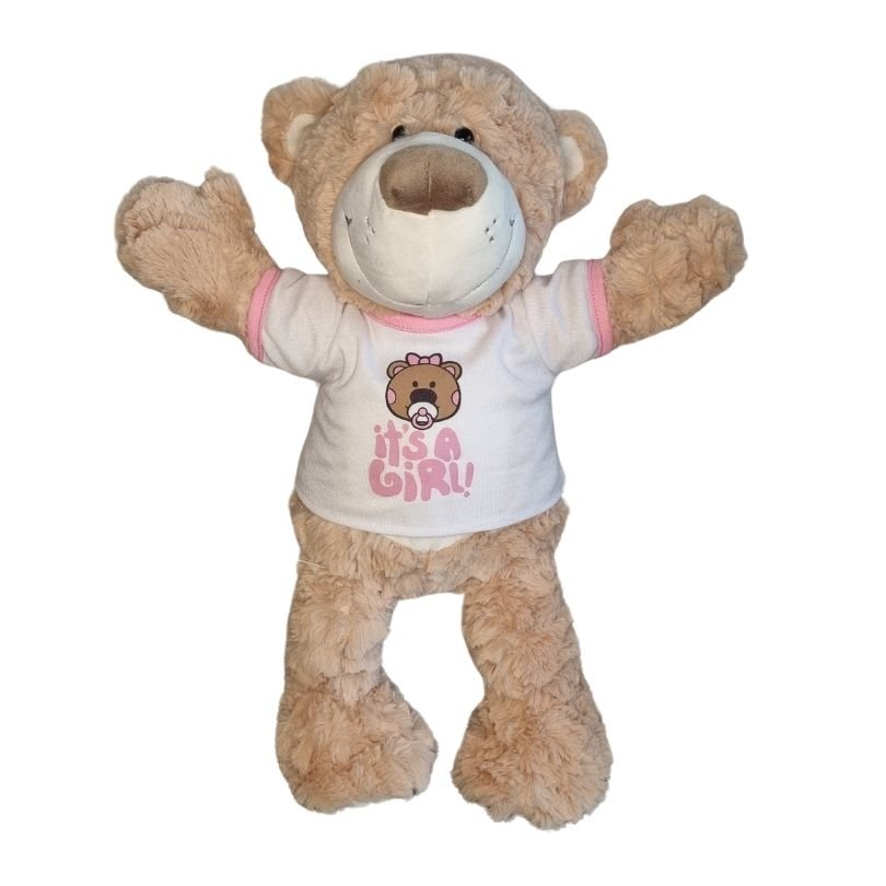 It's a Girl – T-shirt - voor Knuffel - Make a bearKnuffel beer met wit 'It's a Girl' T-shirt, roze tekst, en een zachte bruine vacht