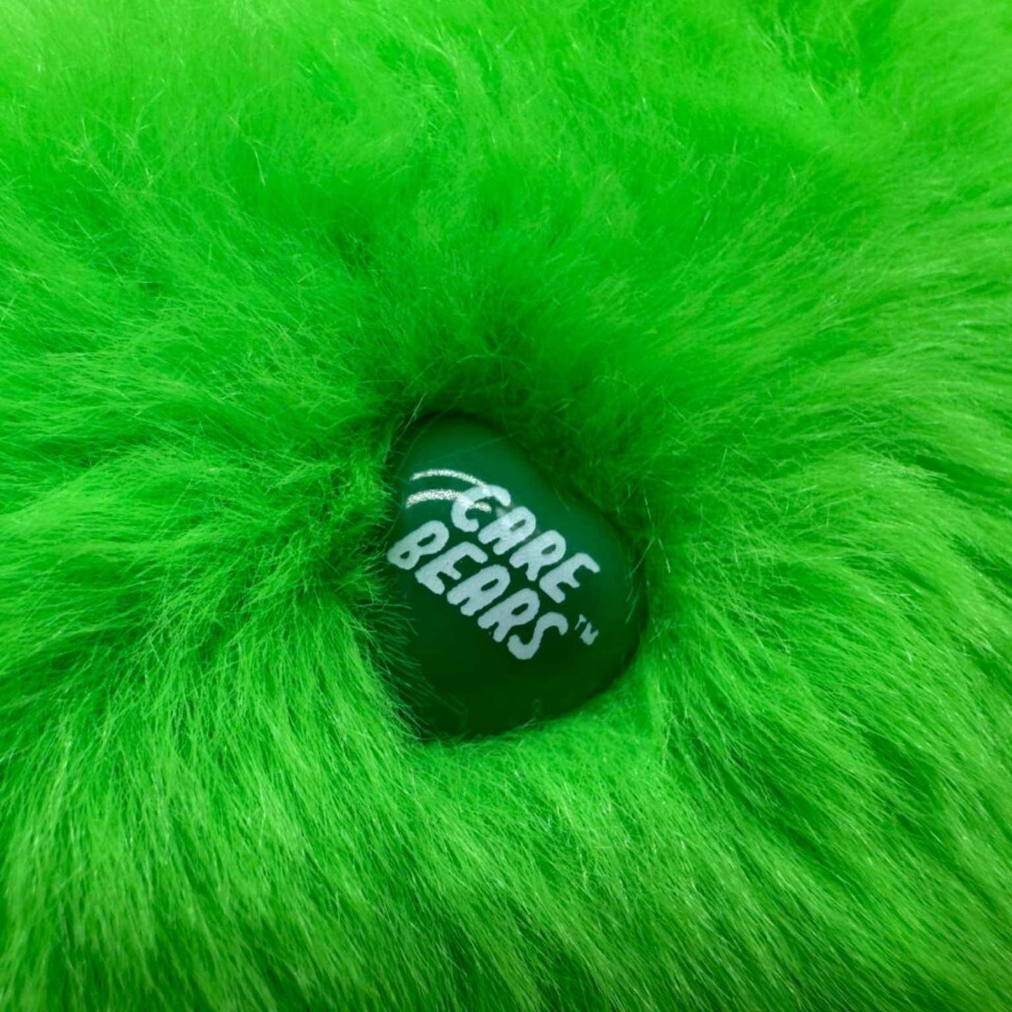 Close-up van het originele Care Bears merkje op Lucky Bear – officieel gelicentieerde knuffel bij Make a Bear