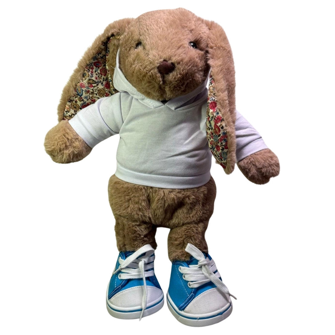 knuffel konijn van Make a Bear heeft hier blauwe sneakers aan. deze schoenen zijn speciaal voor knuffel. Ze zijn blauw en wit van kleur. 