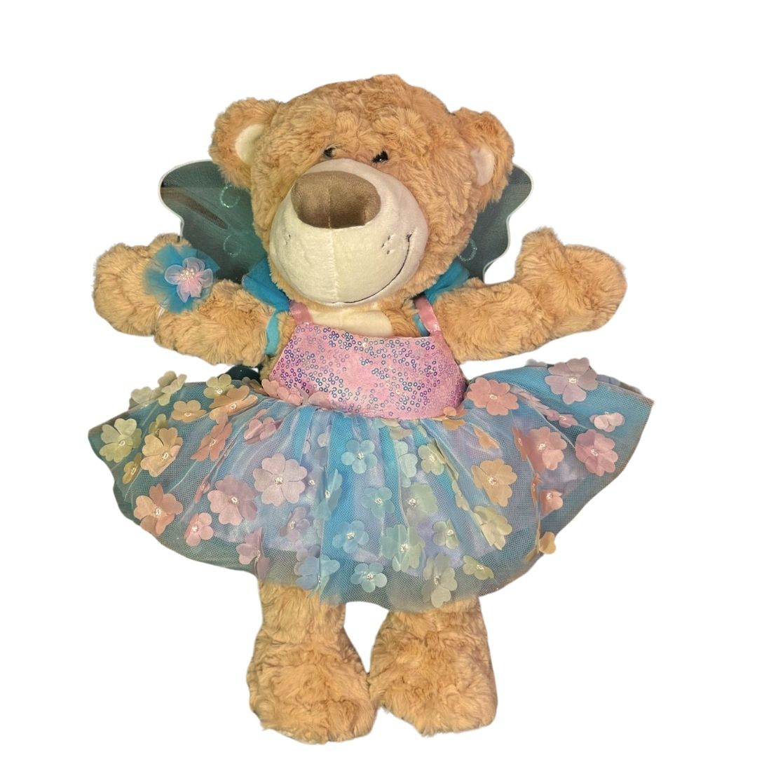 Milo de knuffel beer met het flowerdress aan en vleugels. Zacht roze en blauwe kleuren, glitter en bloemetjes